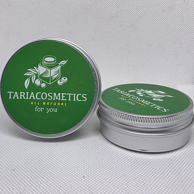 Two circular silver metal tins against a white background with the left tin positioned upright to show green lid with TariaCosmetics label.