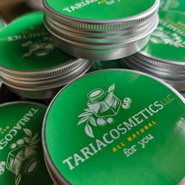 Stack of Tariacosmetics containers with green lids and silver bodies.