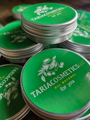 Stack of Tariacosmetics containers with green lids and silver bodies.