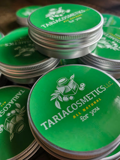 Stack of Tariacosmetics containers with green lids and silver bodies.