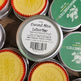 Collection of coconut olive lotion bars with visible branding on tins.