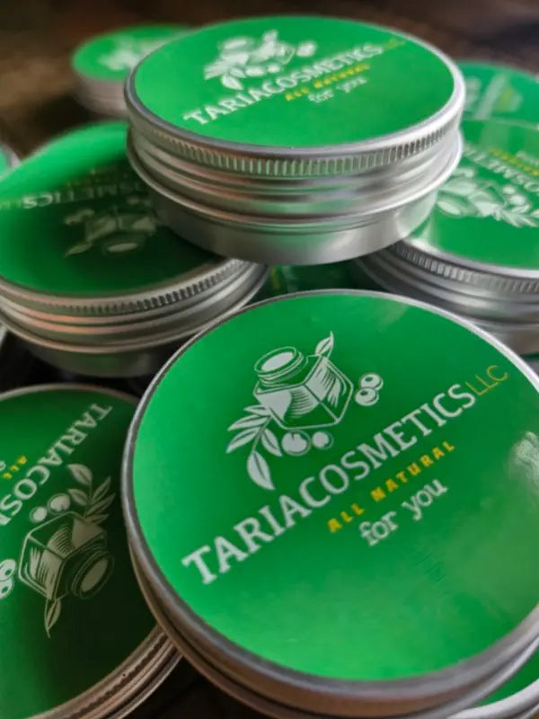 Stack of Tariacosmetics containers with green lids and silver bases.