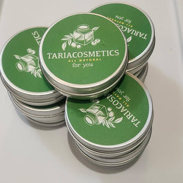A stack of round aluminum tins featuring a green label with the branding of TariaCosmetics on them.