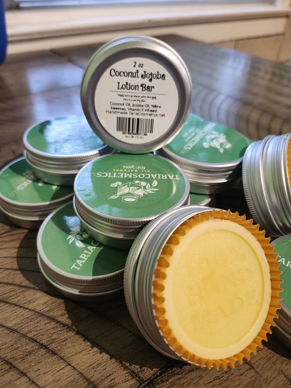 Stack of coconut jojoba lotion bars in circular silver metal tins