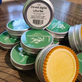 Stack of coconut jojoba lotion bars in circular silver metal tins