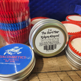Jars of a cosmetic product with visible branding on a textured surface.