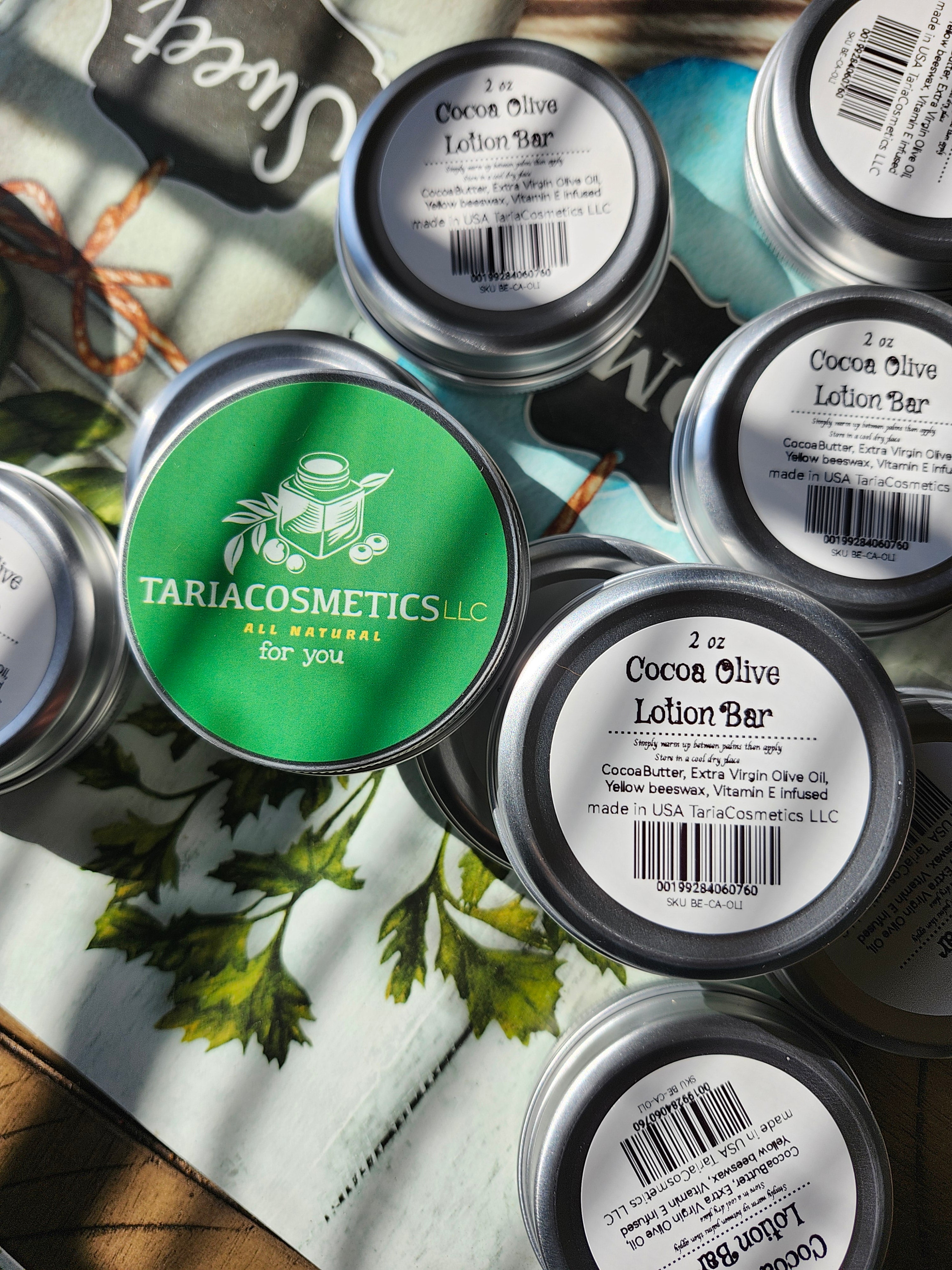 Multiple containers of TariaCosmetics on a surface with greenery