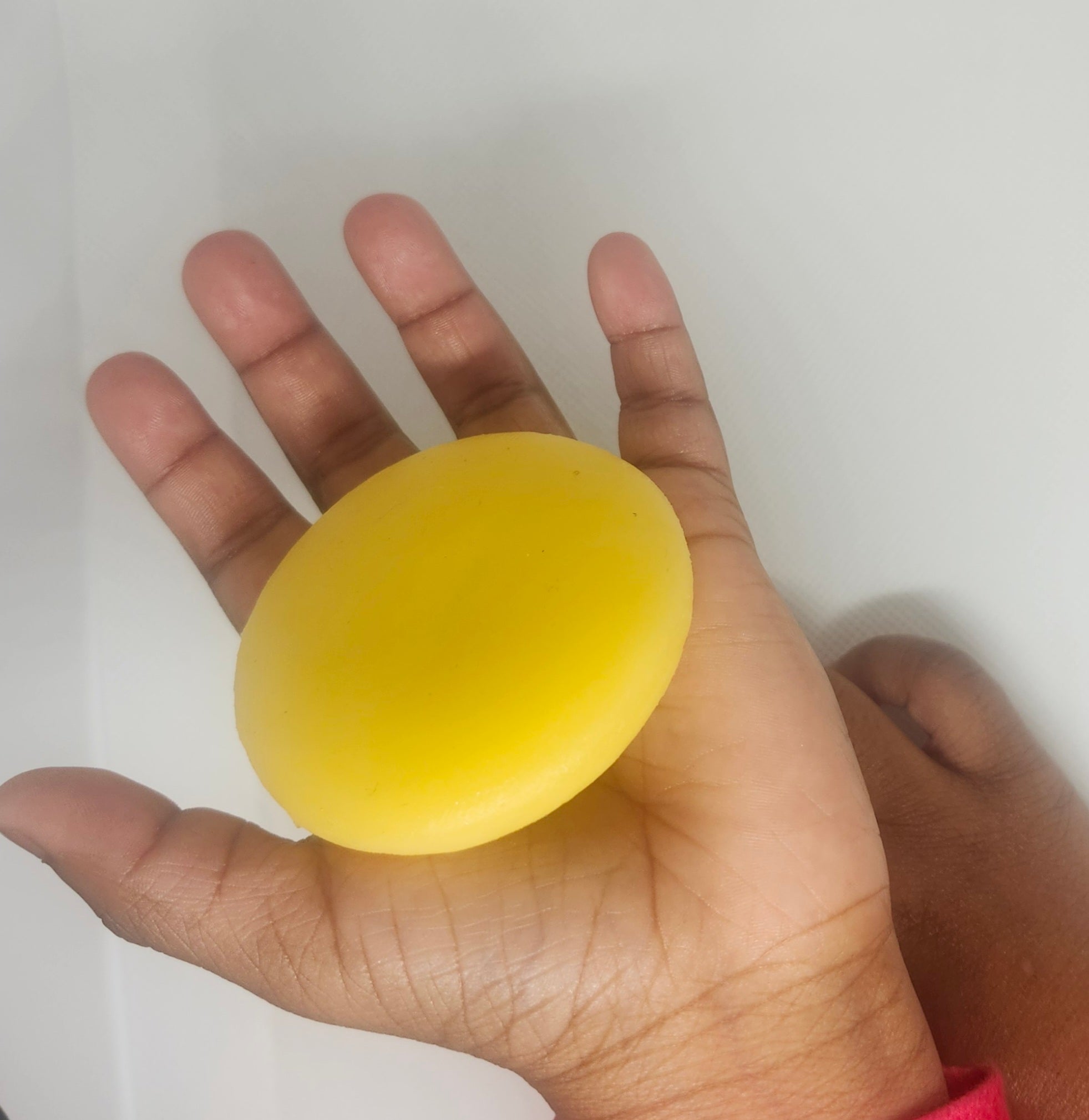 Child's hand open with tan lotion bar in it.