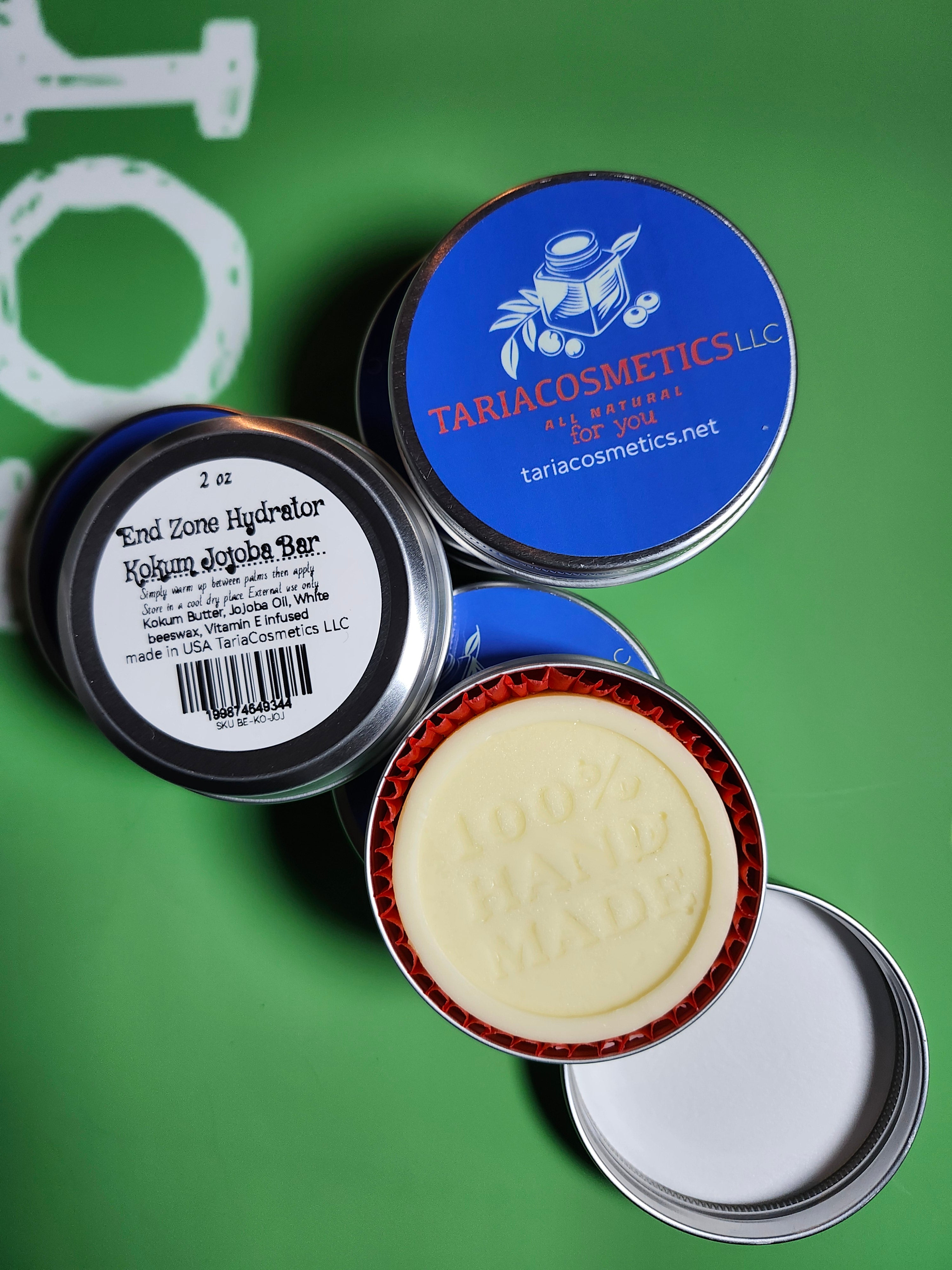 Collection of cosmetic tins with visible branding on a green background