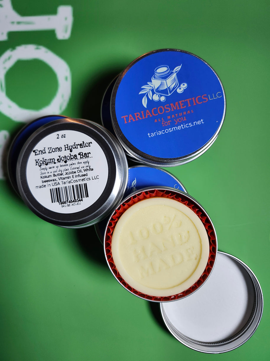 Collection of cosmetic tins with visible branding on a green background