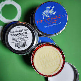 Collection of cosmetic tins with visible branding on a green background