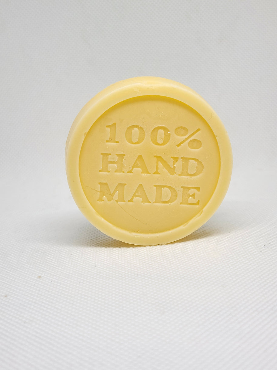 A lotion bar standing upright with 100% HANDMADE embedded in it