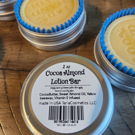 Cocoa Almond Lotion Bar in a metal container with a label on a wooden surface
